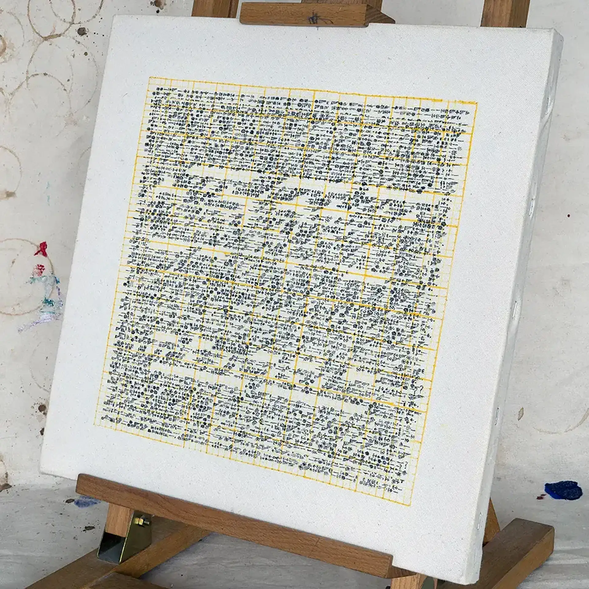 Here is your letter [~] artwork of letterforms and ink in yellow and black on a square unprimed canvas by Daniel Cosentino